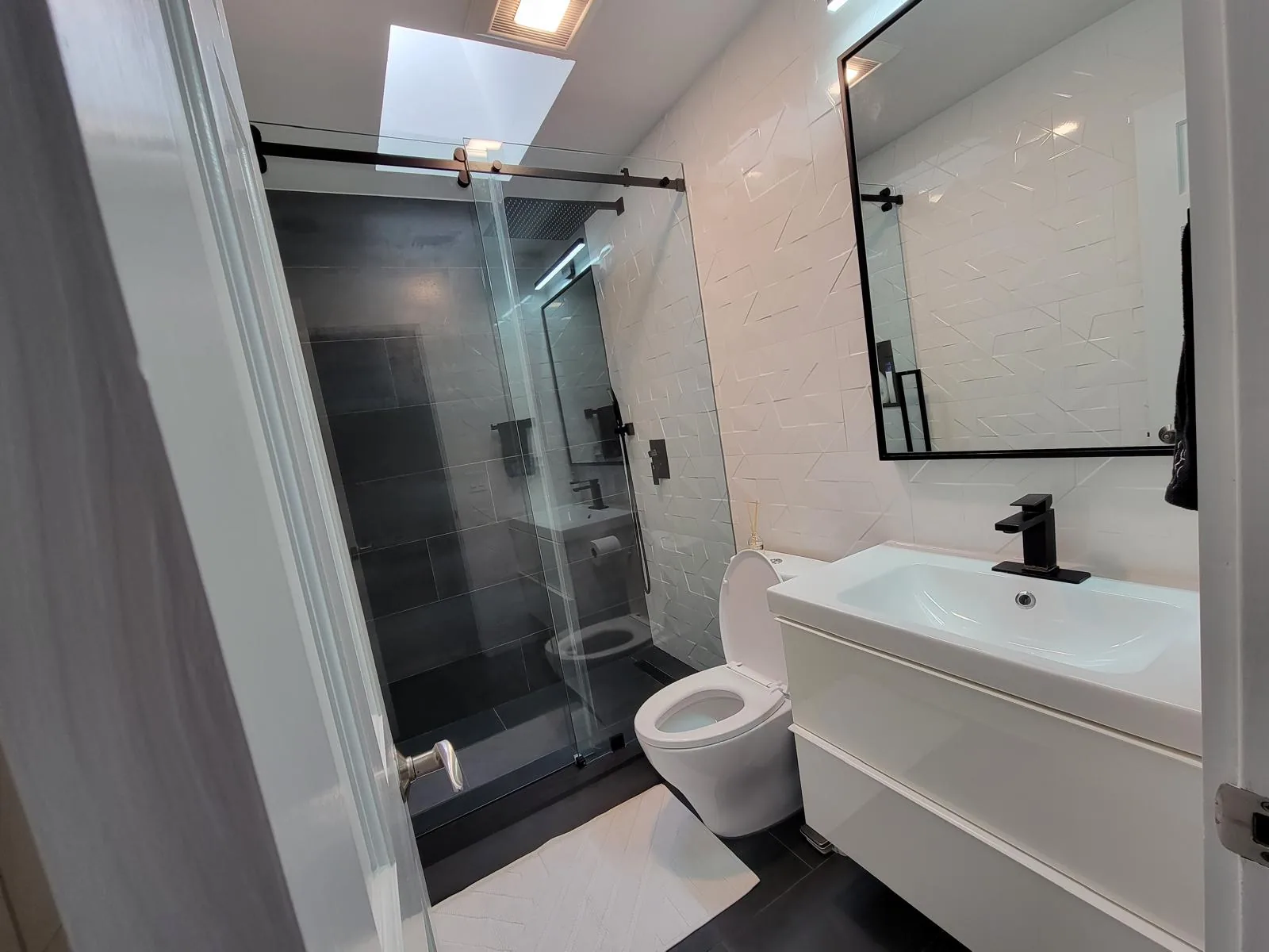Spotless modern bathroom with a glass walk-in shower and white vanity